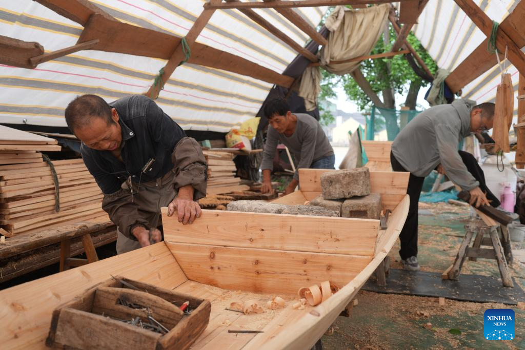 Qian Shoutan sedang membuat bot kajang hitam bersama-sama dengan perantisnya di di Shaoxing, Provinsi Zhejiang, di timur China pada 12 Jun 2025. (Xinhua/Weng Xinyang)