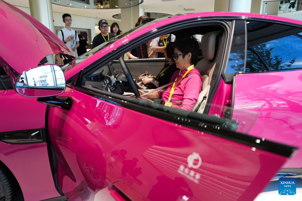 Pengunjung mempelajari mengenai kenderaan tenaga baharu di kilang automobil Xiaomi di Beijing, pada 16 Jun 2025. (Xinhua/Zheng Huansong)