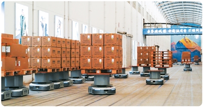 Robot pintar penghantar barang sedang beroperasi di pusat logistik pintar Bosideng di bandar Changshu, Provinsi Jiangsu di timur China. (foto insan individu yang diwawancara)