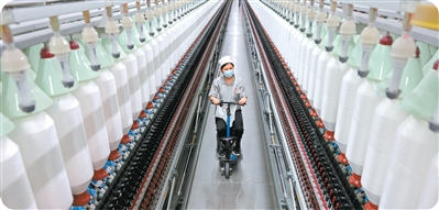 Seorang pekerja memeriksa barisan pengeluaran benang automatik mewah di sebuah syarikat di Provinsi Shandong, timur China, pada 15 April 2025. (Foto oleh Sun Zhongzhe)