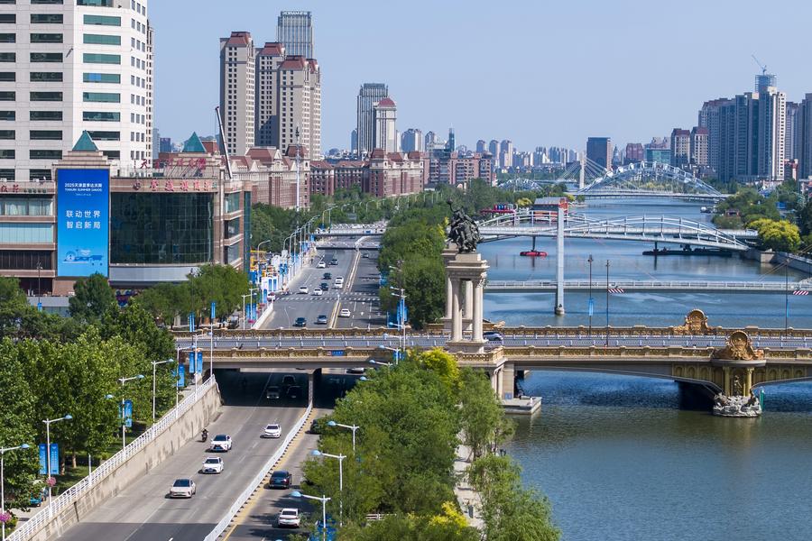 Foto sudut udara yang diambil menggunakan dron pada 21 Jun 2025 ini memperlihatkan poster Davos Musim Panas 2025 tergantung di bangunan di sekitar Sungai Haihe di Perbandaran Tianjin di utara China. (Xinhua/Zhao Zishuo)