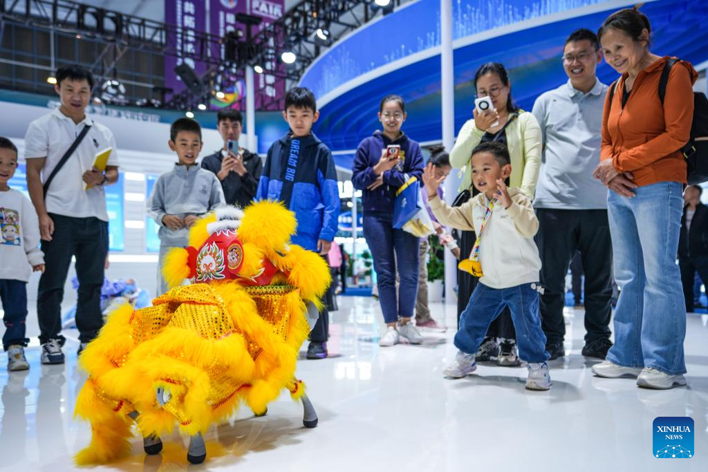 Pengunjung berinteraksi dengan anjing robotik semasa Ekspo China-Asia Selatan yang ke-9 di Kunming, Provinsi Yunnan di barat daya China pada 22 Jun 2025. (Xinhua/Chen Ximbo)