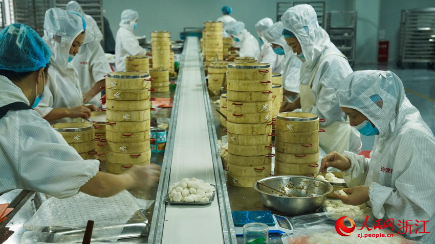 Pekerja membuat roti sumbat kukus di sebuah syarikat ban kukus berinti di Shengzhou, Provinsi Zhejiang, timur China. (People's Daily Online/Guo Yang)