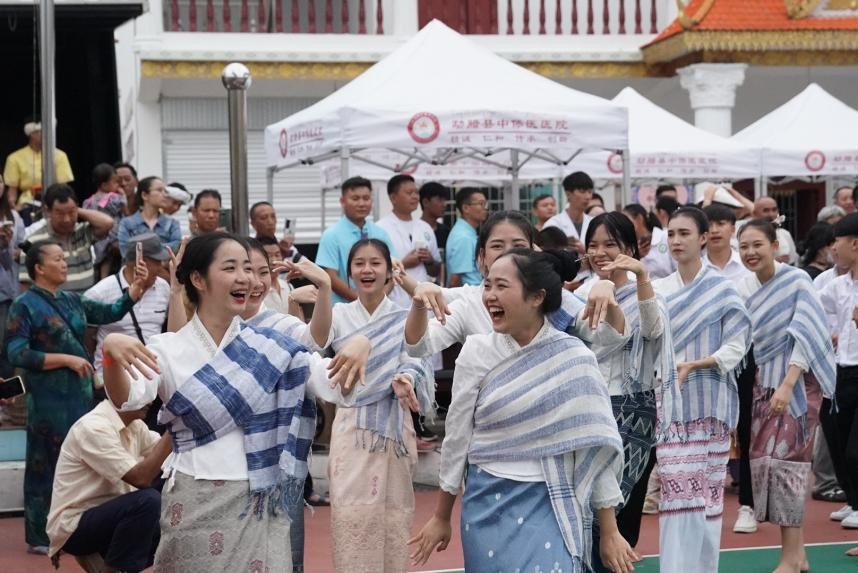 Pelajar Laos dari Sekolah Menengah Vokasional Mengla menyertai himpunan pasar di sempadan China-Laos. (Foto oleh Wang Zi)
