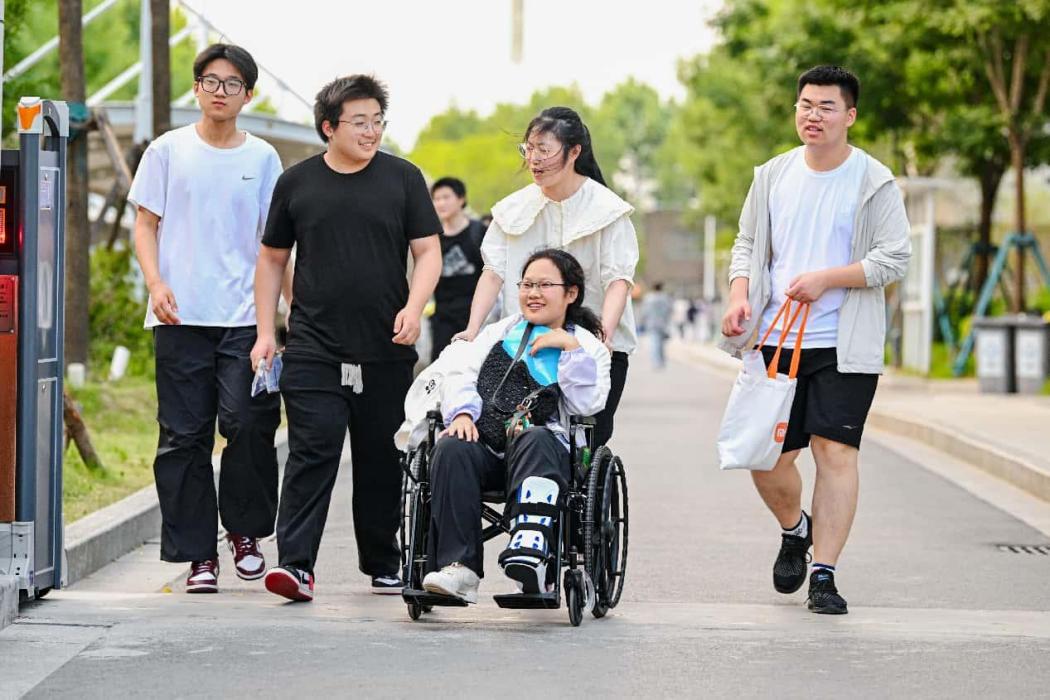 Beberapa orang pelajar membantu rakan sekelas yang kurang berkemampuan untuk keluar daripada venue peperiksaan di Suqian, Provinsi Jiangsu, timur China pada 9 Jun 2025. (People’s Daily Online/Chen Hong)