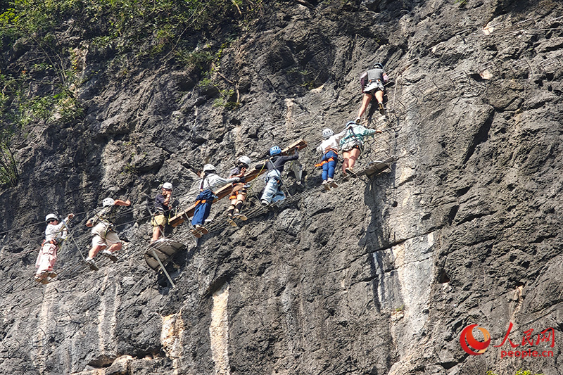 Foto ini memaparkan ‘kesesakan lalu lintas’ sebentar di dinding batuan yang menyaksikan pemanjat sedang menunggu giliran masing-masing dalam sebuah aktiviti luar bilik yang berpangkalan di kampung Longcun, kaunti Yangshuo, bandar Guilin, Wilayah Autonomi Zhuang Guangxi di selatan China. (People’s Daily Online/Lei Qijun)