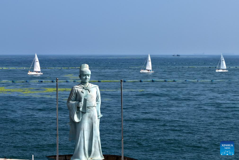 Foto dron bertarikh 10 Julai 2025 ini memperlihatkan patung Laksamana Cheng Ho serta perahu-perahu layar yang menyertai acara pelayaran di laut berdekatan sebuah dok di Qingdao, provinsi Shandong, timur China. (Xinhua/Li Ziheng)