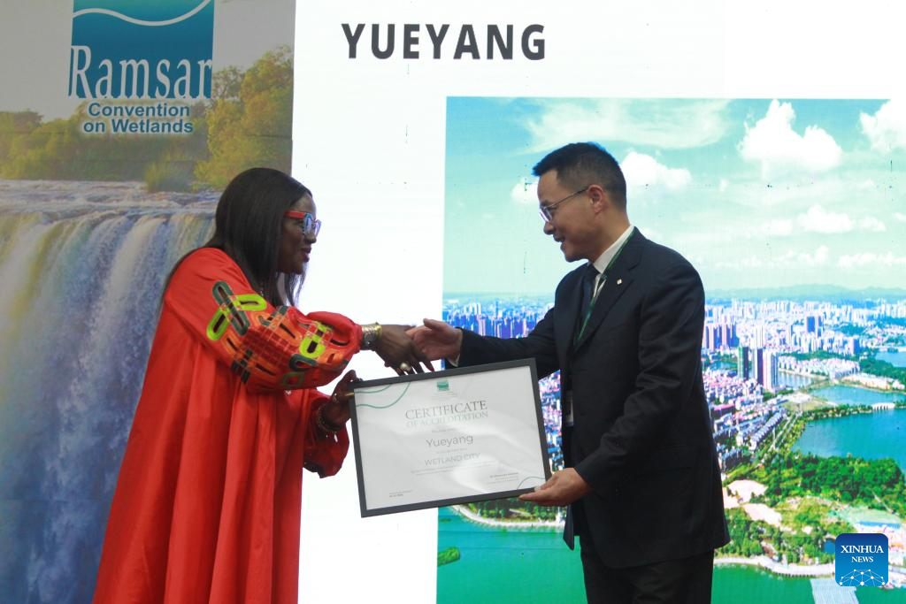 Musonda Mumba (kiri), setiausaha agung Konvensyen untuk Tanah Lembap, menyerahkan sijil akreditasi bandar tanah lembap antarabangsa kepada seorang wakil dari Hangzhou, Provinsi Zhejiang, pada 24 Julai 2025 di Victoria Falls, Zimbabwe. Sejumlah sembilan bandar raya China telah ditauliahkan sebagai bandar tanah lembap antarabangsa pada Khamis semasa pembukaan Mesyuarat Ke-15 Persidangan Pihak Penjanji kepada Konvensyen Ramsar mengenai Tanah Lembap (COP15) yang diadakan di bandar peranginan Victoria Falls, Zimbabwe, menjadikan jumlah keseluruhan bandar seumpama itu di China kepada 22 bandar, iaitu yang terbanyak di dunia. (Xinhua/Tafara Mugwara)