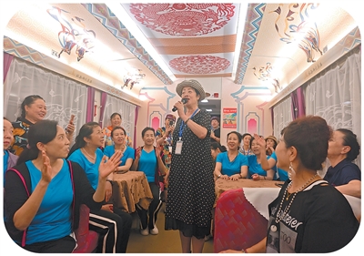 Seorang penumpang menyanyi di dalam ‘kereta api perak’ di Provinsi Gansu, di barat laut China. (Foto oleh Cao Wenfu)