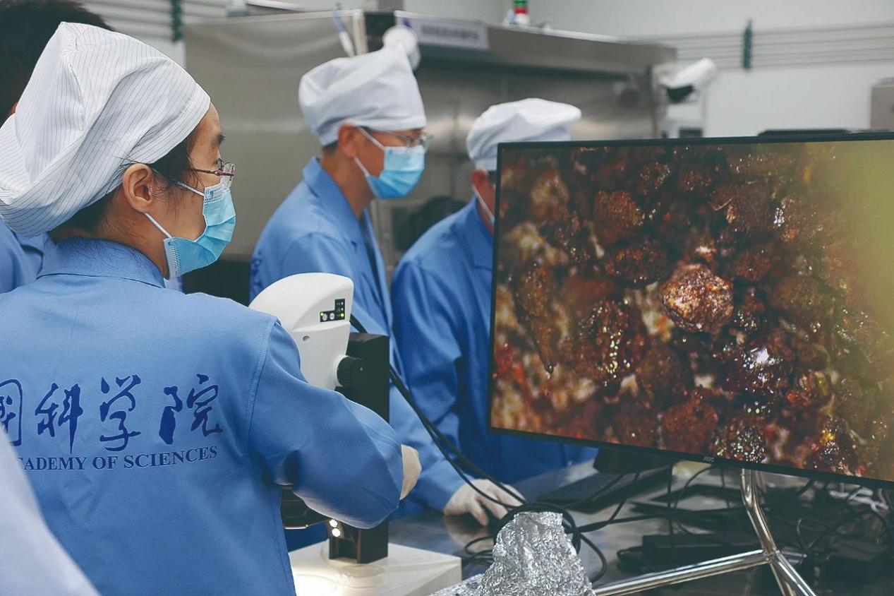 Penyelidik dari Balai Cerap Astronomi Kebangsaan, Akademi Sains China, meneliti imej mikroskop serpihan batu bulan. (Foto ihsan Balai Cerap Astronomi Kebangsaan, Akademi Sains China)
