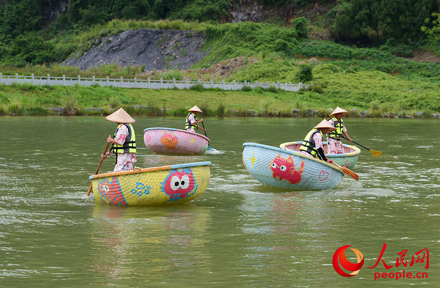 Pengemudi bot berpakaian yang bertemakan kucing mendayung ‘bot Boji’, sejenis bot berbentuk dulang penampi buluh baharu yang dihiasi lukisan kucing, di sebatang sungai di kaunti Yangshuo, bandar Guilin, Wilayah Autonomi Guangxi Zhuang, di selatan China. (People’s Daily Online /Liang Zhanghui)