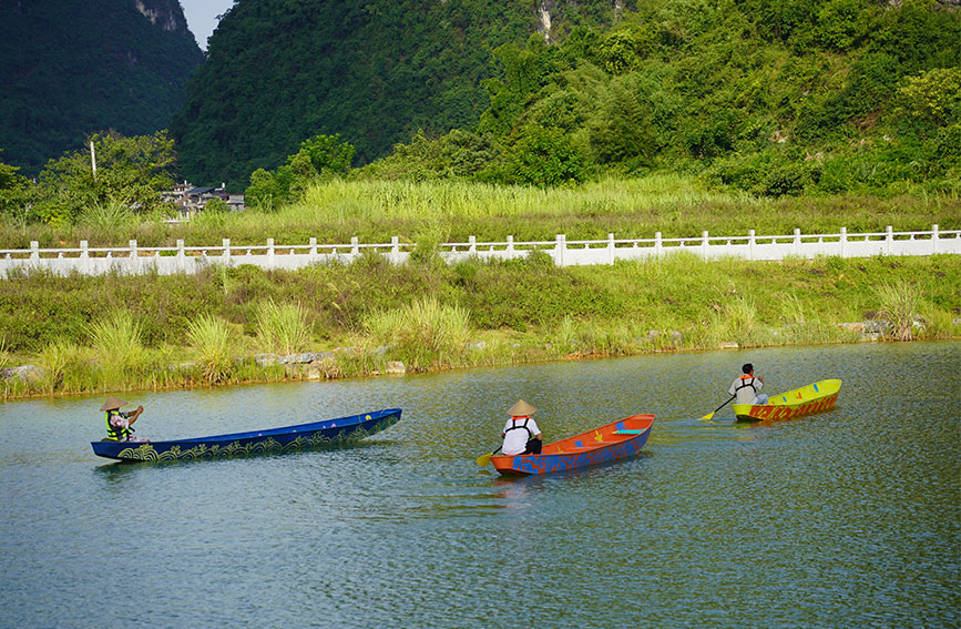 Foto menunjukkan pengemudi bot dan pelancong mendayung bot berbentuk daun willow di sebatang sungai di kaunti Yangshuo, bandar Guilin, di Wilayah Autonomi Zhuang Guangxi, selatan China. (Foto oleh Fang Yu)