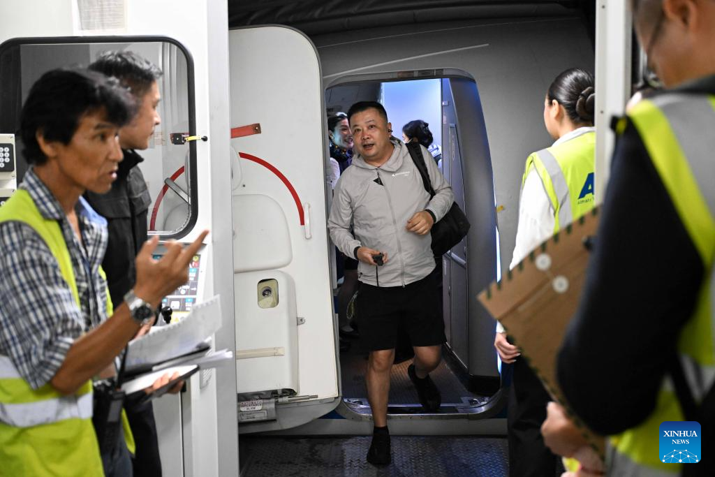 Seorang penumpang yang menaiki penerbangan sulung baharu dari Beijing ke Almaty berjalan keluar dari kabin di Lapangan Terbang Antarabangsa Almaty di Kazakhstan pada 30 Julai 2025. (Xinhua/Li Renzi)