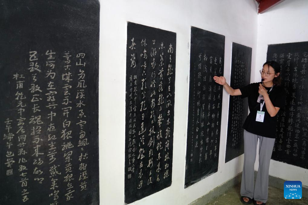 Seorang pemandu pelancong memperkenalkan kepada pelancong sajak-sajak oleh penyajak purba China, Du Fu di tapak peringatan Du Fu di Kaunti Chengxian, Provinsi Gansu di barat laut China pada 13 Julai 2025. (Xinhua/Ma Ning)