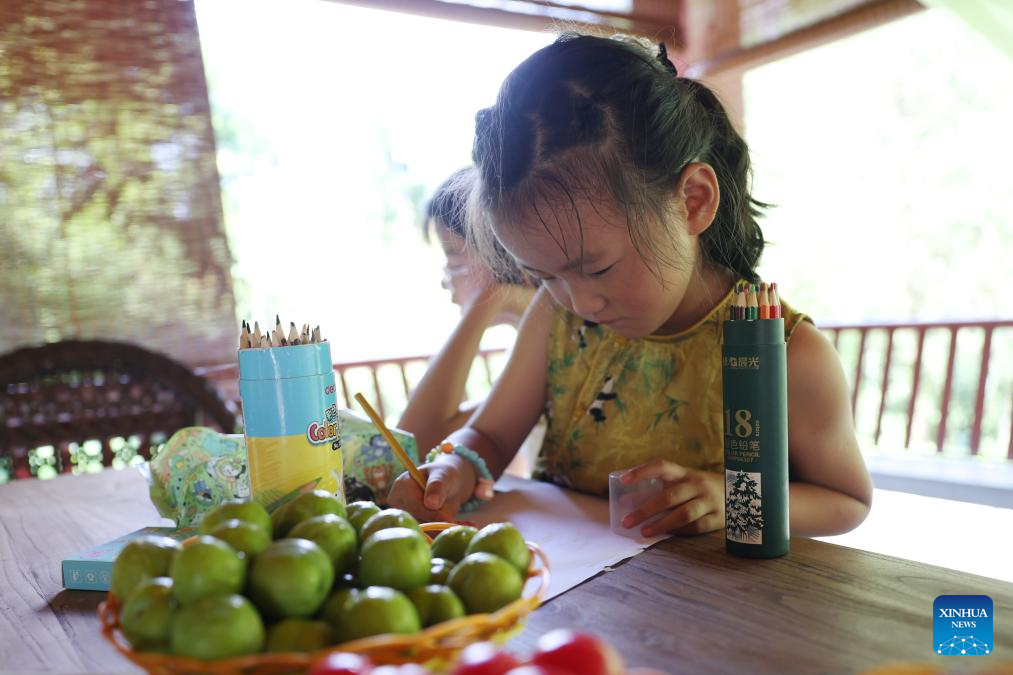 Seorang kanak-kanak sedang melukis di rumah teh di tapak peringatan Du Fu di Kaunti Chengxian, Provinsi Gansu di barat laut China pada 13 Julai 2025. (Xinhua/Chen Bin)