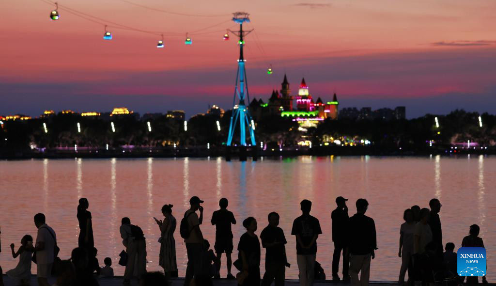 Orang ramai menikmati sinaran matahari tenggelam di tepi Sungai Songhua di Harbin, Provinsi Heilongjiang, timur laut China pada 25 Julai 2025. (Xinhua/Zhang Shu)