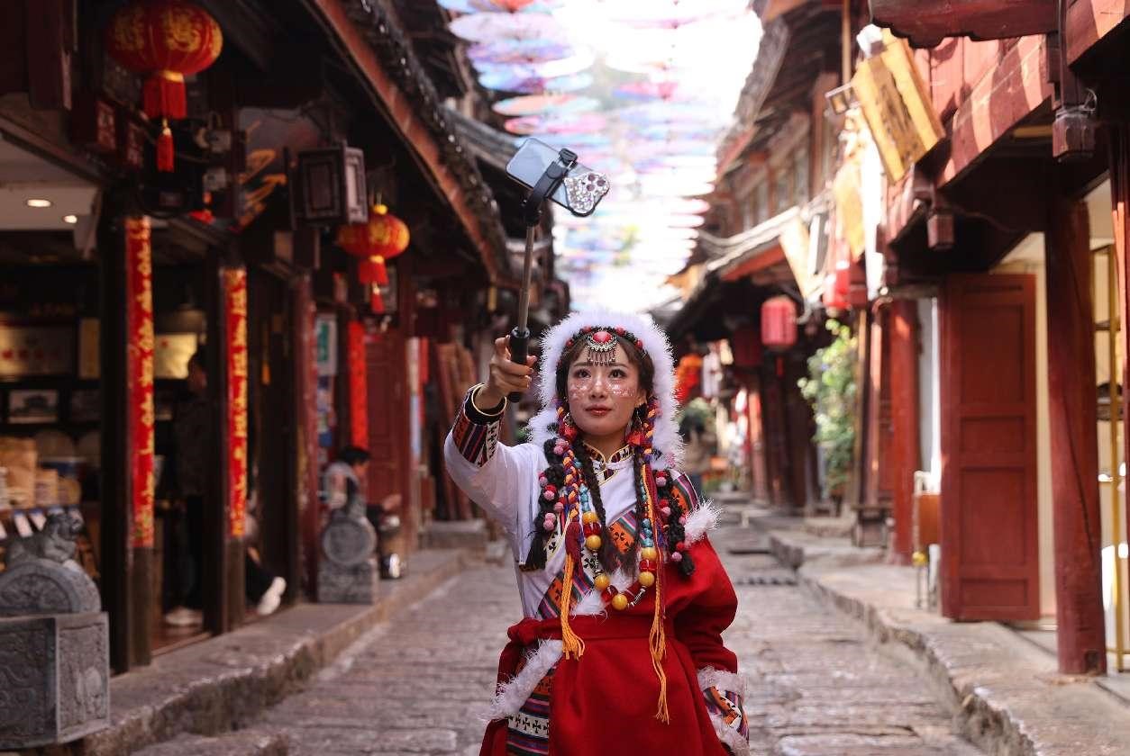 Seorang wanita sedang bergaya untuk berswafoto di pekan purba Lijiang di Provinsi Yunnan di barat daya China. (Foto oleh Liang Zhiqiang)