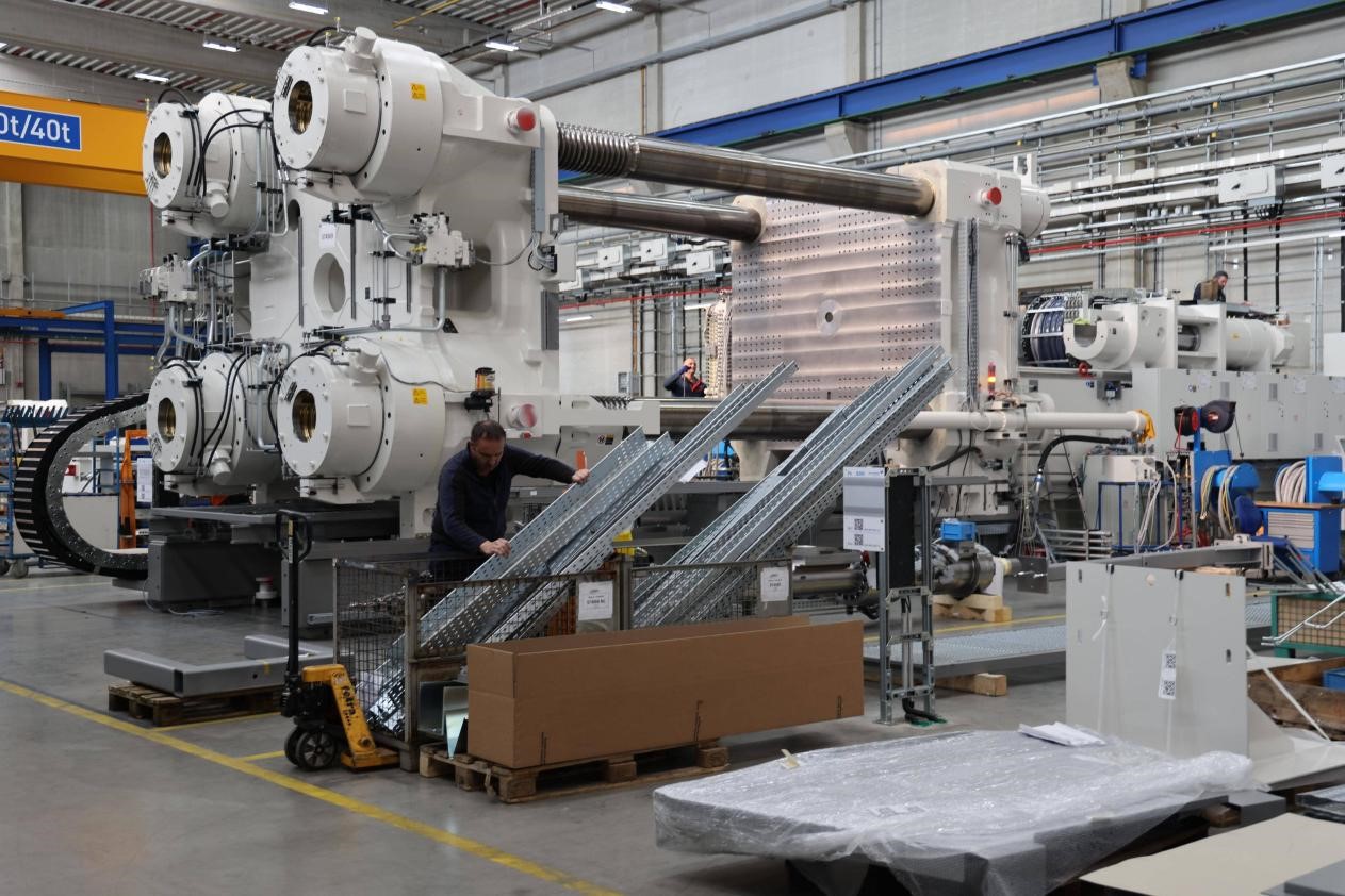 Juruteknik memasang dan menggunakan peralatan pengacuan suntikan besar di dalam bengkel di kilang baharu KraussMaffei. (People’s Daily/Liu Zhonghua)