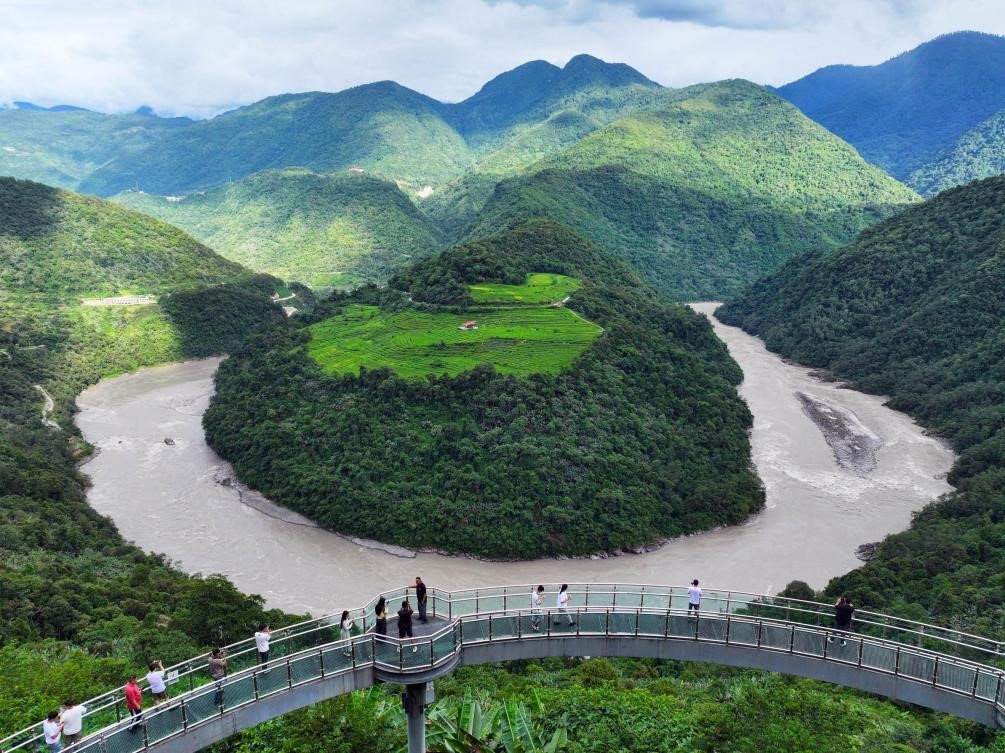 Pelancong menikmati pemandangan nan indah Pusingan Besar Guoguotang Sungai Zangbo Yarlung di kampung Dexing, kaunti Metok di Wilayah Autonomi Xizang di barat daya China. (Foto oleh Zhang Yuanming)