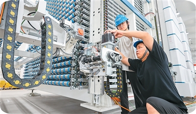 Juruteknik di Syarikat Zhejiang Yugong Intelligent Equipment sedang memeriksa dan menentukur komponen peralatan untuk dieksport ke Amerika Syarikat. (Foto oleh Yao Haoxiang)