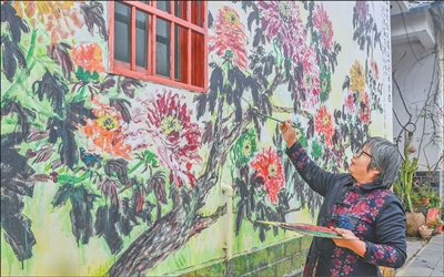 Seorang artis sedang mengecat satu mural di kampung Quanyongdong, pekan Lingshan, daerah Meilan, Haikou, Provinsi Hainan di selatan China. (Foto oleh Sun Shijie)