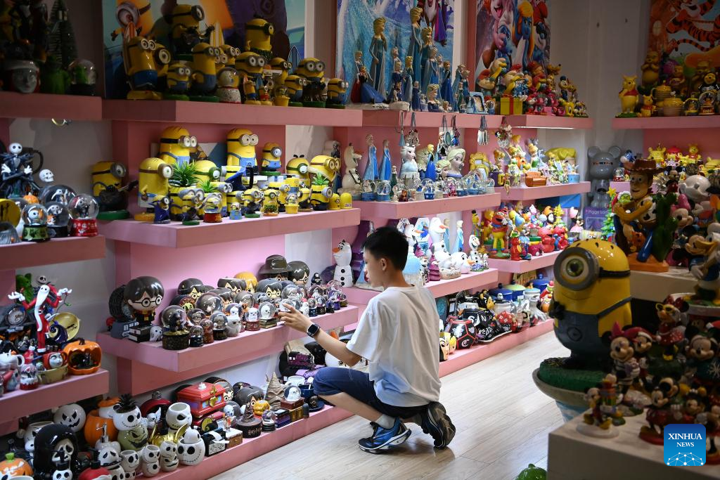 Seorang kanak-kanak mendekati seni porselin yang dipamerkan di kaunti Dehua, Provinsi Fujian, tenggara China pada 20 Ogos 2025. (Xinhua/Xiao Xiao)