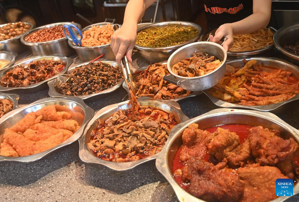 Seorang pekerja menambah lauk di atas semangkuk Luosifen di sebuah restoran di Nanning, Wilayah Guangxi, pada 18 September 2025. (Xinhua/Lu Boan)