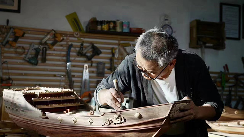 Fu Kunxiang mengukir sebuah model kapal armada Zheng He. (Foto ihsan individu yang diwawancara)
