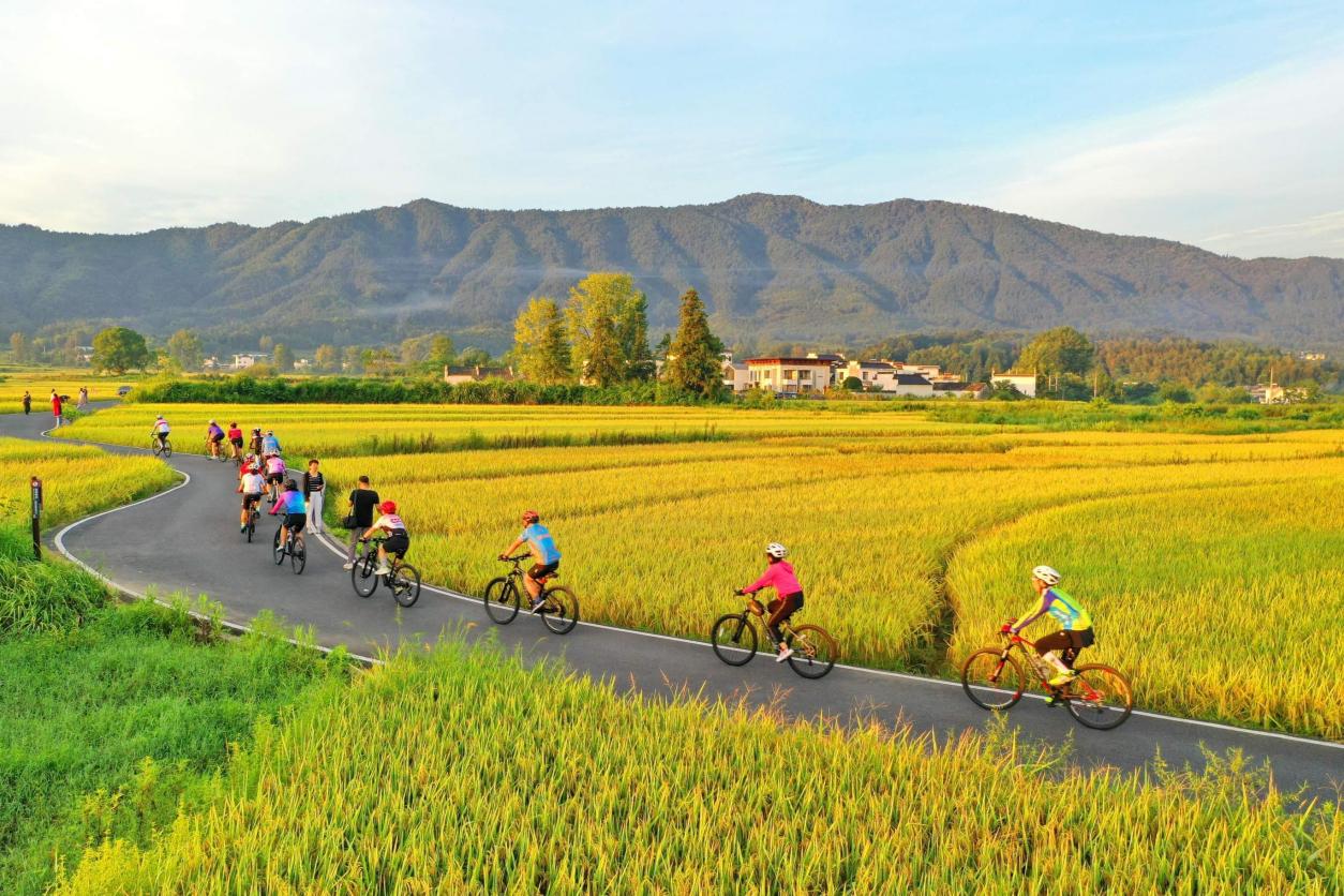 Orang ramai mengayuh basikal di sebatang jalan desa di kampung Guanlu, kaunti Qianxian, Huangshan, Provinsi Anhui di timur China. (Foto oleh Xu Jiadong)