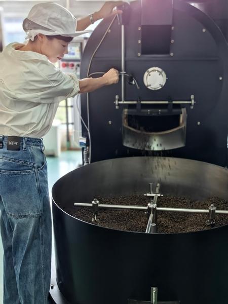 Wen Shan, juruteknik pemprosesan kopi, sedang memanggang biji kopi di sebuah kilang di Xiamen, Provinsi Fujian, tenggara China. (Foto ihsan individu yang diwawancara)