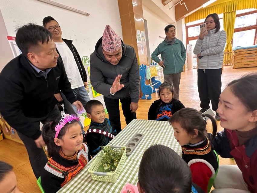 Seorang wartawan dari Nepal mempelajari bahasa kumpulan Etnik Yi dari kanak-kanak di sebuah tadika di kaunti Zhaojue, Kawasan Autonom Yi Liangshan, Provinsi Sichuan barat daya China, menyambut delegasi media dari rantau Asia-Pasifik. (Foto oleh Zhang Yuxin)