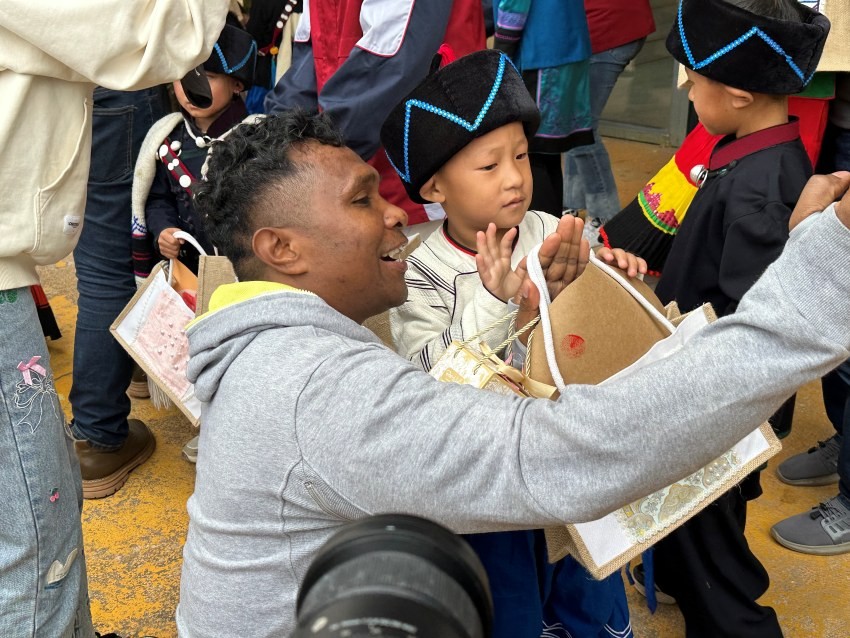 Wartawan dari Timor Leste berswafoto dengan salah seorang kanak-kanak yang memberikan cenderamata kepada delegasi media dari Asia Pasifik. (Foto oleh Zhang Yuxin)
